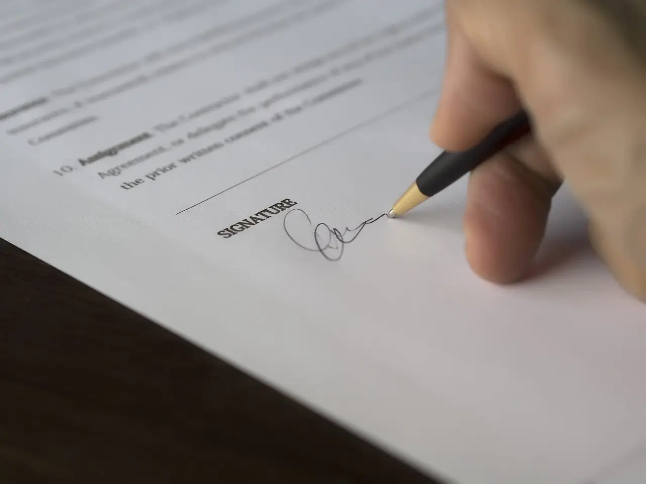 Someone signing a contract with a pen